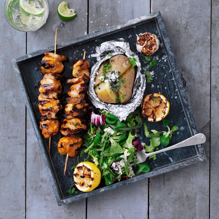 Grillspyd med brystfilet, bagte kartofler og grillede hvidløg