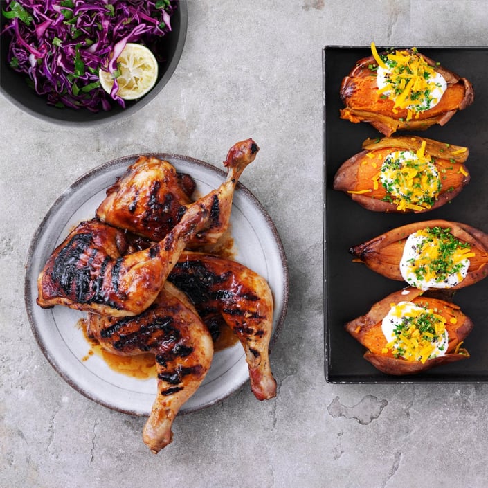 Spicy kyllingelår med bagte søde kartofler og rødkålssalat