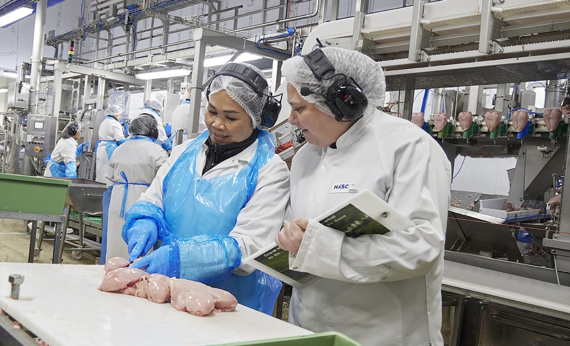 Karina i dialog med en kollega i produktionen